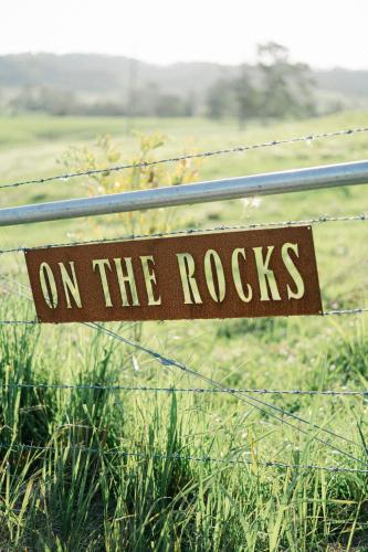 a sign on a fence that reads on the rocks at Whisky @ On The Rocks in Rock Valley