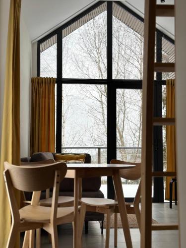 a dining room with a table and chairs and a large window at Domki Piwniczna in Piwniczna