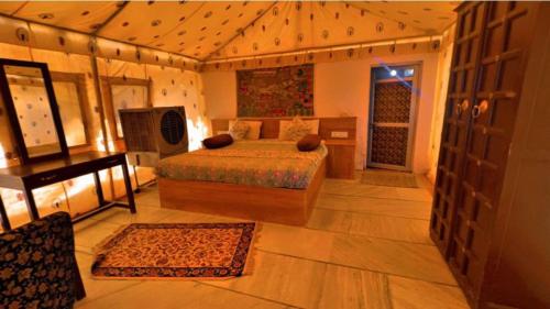 a bedroom with a bed and a desk and a bed sidx sidx sidx at Excellent Desert Safari camp in Sām