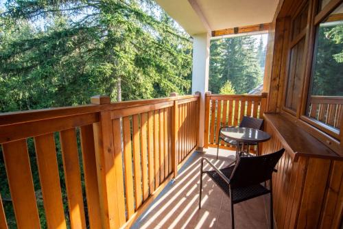 a porch with two chairs and a table on it at Malina Apartamenty in Szklarska Poręba