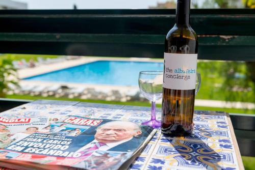 a bottle of wine next to a magazine and a glass at TAC - Vilamoura Center in Vilamoura