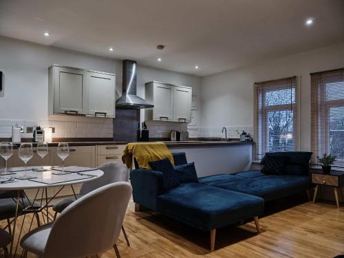 Grange Lane في مانشستر: غرفة معيشة مع أريكة زرقاء وطاولة