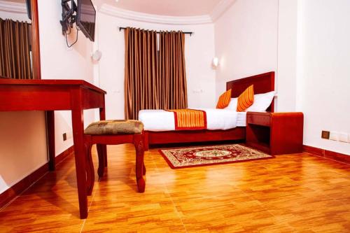 1 dormitorio con 1 cama con escritorio y silla en Vedoko appart'hotel, en Cotonou