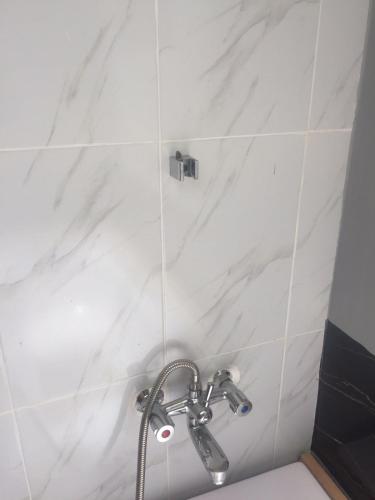 a shower in a bathroom with white marble tiles at Amanya 3-Bedroom Hut Amboseli in Amboseli