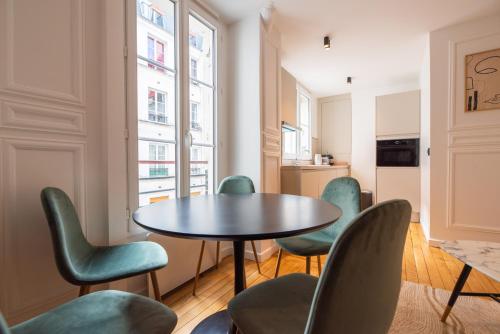 une salle à manger avec une table et des chaises dans l'établissement Lovely apartment Near Canal St Martin, à Paris