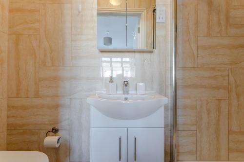 a bathroom with a white sink and a shower at Room in Guest room - Apple House Wembley in Edgware