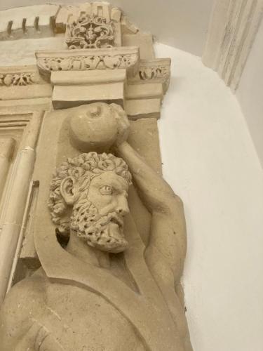 a statue of a man on the side of a building at Palazzo Prence in Copertino