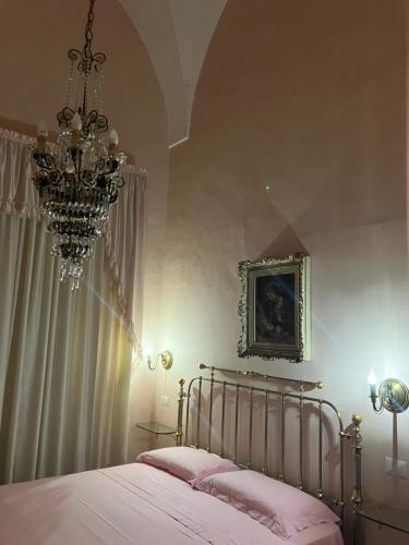 a bedroom with a bed and a chandelier at Palazzo Prence in Copertino