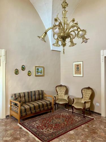 a living room with a couch and two chairs and a chandelier at Palazzo Prence in Copertino