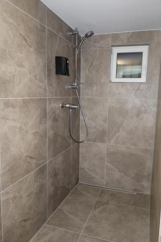 a shower with a shower head in a bathroom at TOKA ROOMS - an der Regiobahn in Mettmann