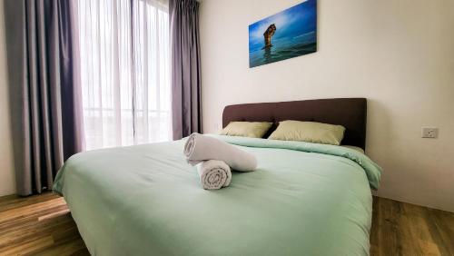 een slaapkamer met een bed met een handdoek erop bij Cozy Home at Near Centre and Airport @ Galacity in Kuching