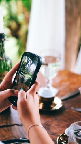 a person holding a cell phone in front of a table at Quinta da Bocaina in Amparo