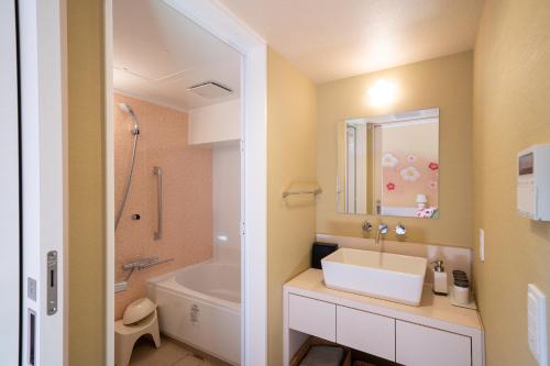 ein Badezimmer mit einem Waschbecken, einer Dusche und einer Badewanne in der Unterkunft BIO-RESORT HOTEL & SPA O Park OGOSE in Ogose