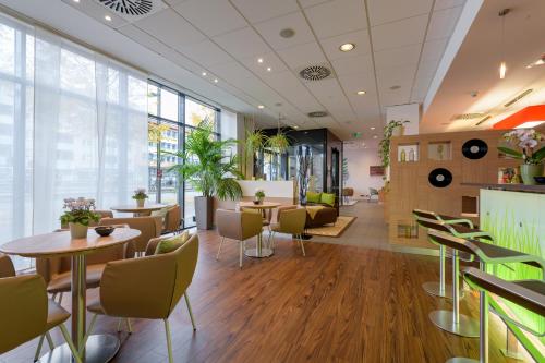 a restaurant with tables and chairs and windows at ibis Heilbronn City in Heilbronn