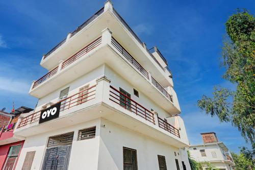 a white building with a sign on it at OYO Flagship Shine Hotel in Chinhat