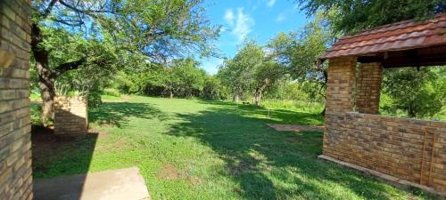 an empty yard with trees and a brick building at El Rancho Grande in Warmbaths