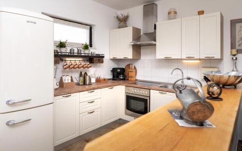 a kitchen with white cabinets and a wooden counter top at Luxury Apartment Flora, Stari Grad, Hvar Island in Stari Grad