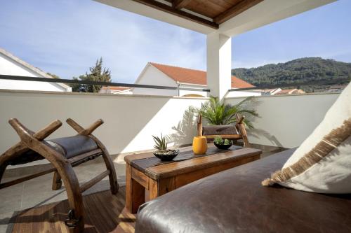 a balcony with a couch and a table and chairs at Luxury Apartment Flora, Stari Grad, Hvar Island in Stari Grad