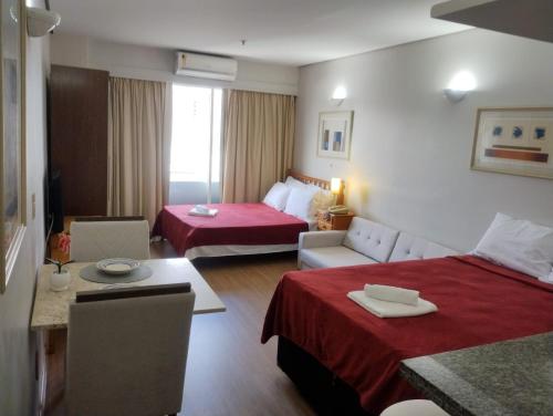a hotel room with two beds and a table at Apto aconchegante - em frente Allianz Parque com estacionamento in São Paulo