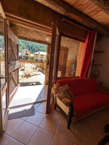 - un salon avec un canapé rouge et une grande fenêtre dans l'établissement Gîte Neige Cordier - Villar d'Arène center 2 bedrooms and large terrace, à Villar-dʼArêne