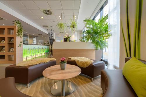 a waiting room with couches and a table at ibis Heilbronn City in Heilbronn