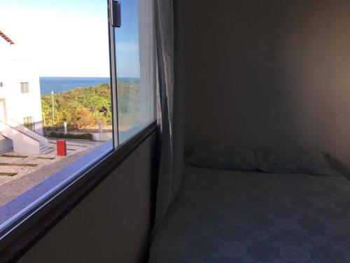 a bedroom with a window with a bed and a view at Apartamento/Flat em Jacumã in Conde