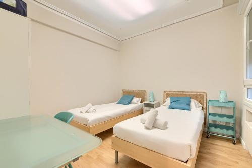 a room with two beds and a table at Euskalduna Apartamento Moderno y Renovado in Bilbao