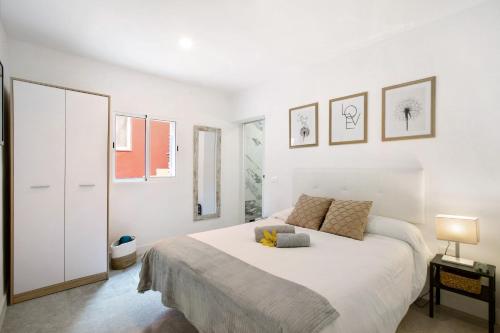 a white bedroom with a large white bed in it at El Ramonal Vacacional in Candelaria
