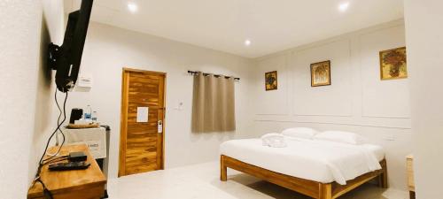 een slaapkamer met een bed met witte lakens en kussens bij Chiang Khan Dwelling in Chiang Khan