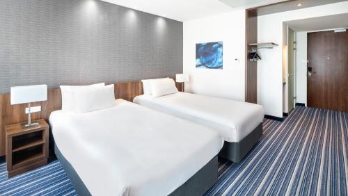 a hotel room with two beds and a door at Holiday Inn Express Amsterdam - South by IHG in Amsterdam