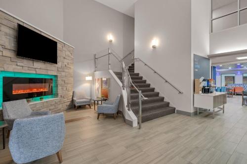 a lobby with a staircase with chairs and a fireplace at Holiday Inn Express Hershey-Harrisburg Area, an IHG Hotel in Hershey