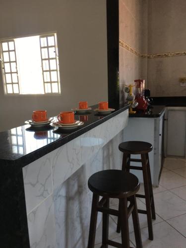 a kitchen with two stools and a counter with food on it at Vista da Serra in Cavalcante