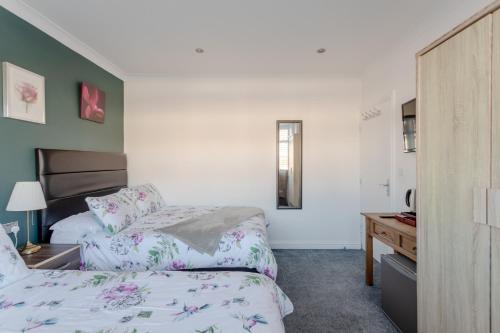 a bedroom with a bed and a dresser and a desk at Room in Guest room - Apple House Wembley - Family room with shared bathroom in Edgware