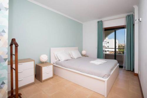 a white bedroom with a bed and a window at The Albufeira Concierge - Modern Salgados in Albufeira