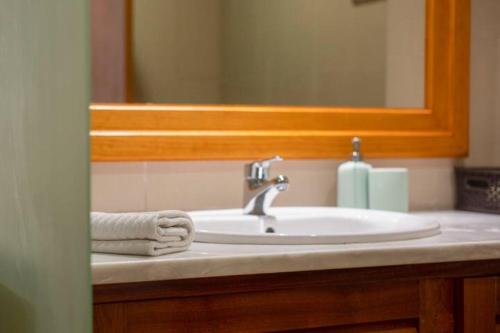 a bathroom sink with a towel and a mirror at The Albufeira Concierge - Modern Salgados in Albufeira