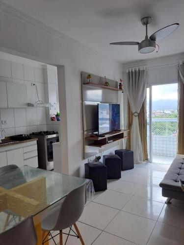 a kitchen and living room with a table and chairs at Apto aconchegante beira mar com ar no quarto in Solemar