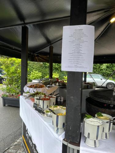 a buffet of food on a table with a sign at Sportalm Gipfelglück in Lüdenscheid