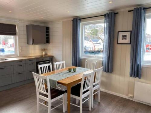 cocina y comedor con mesa y sillas en Damperiholmen cabin en Sund