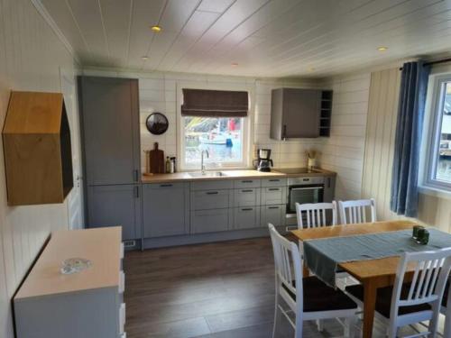 a kitchen with a table and chairs and a dining room at Damperiholmen cabin in Sund