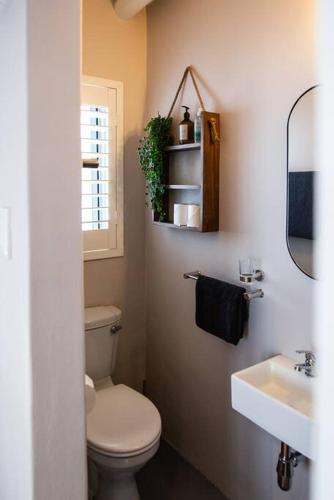 a bathroom with a toilet and a sink and a mirror at Karibu in Paternoster