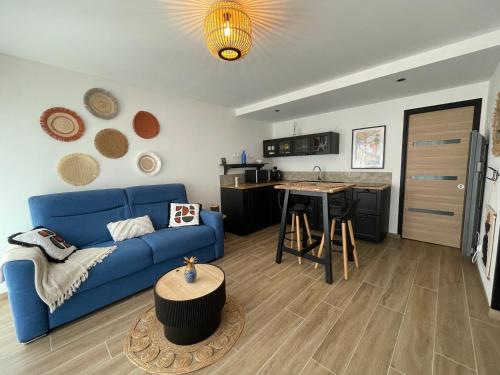 sala de estar con sofá azul y cocina en Studio le petit écureuil en Carnac