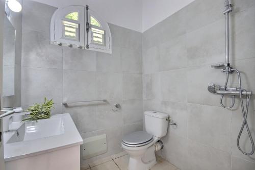 a bathroom with a toilet and a sink at Palmier Rouge in Sainte-Luce