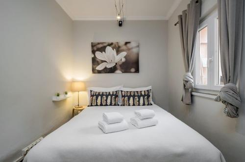 a bedroom with a white bed with two pillows at Sant'Ana Cottage in Cascais