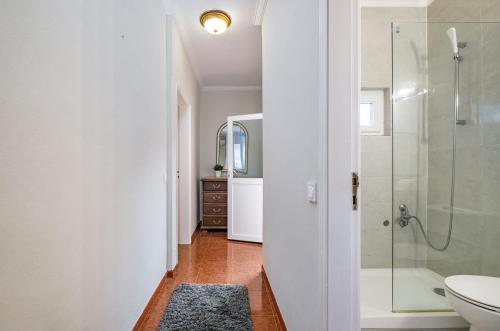 een badkamer met een douche, een toilet en een wastafel bij Sant'Ana Cottage in Cascais