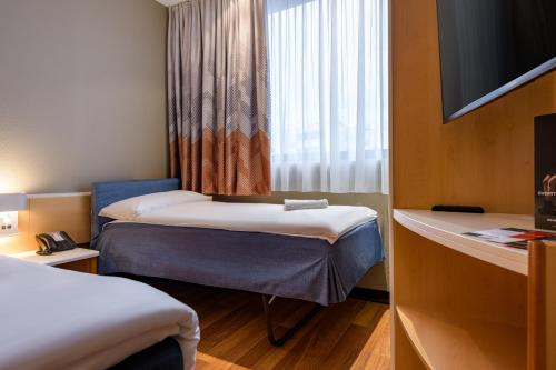 a hotel room with two beds and a window at ibis Heilbronn City in Heilbronn