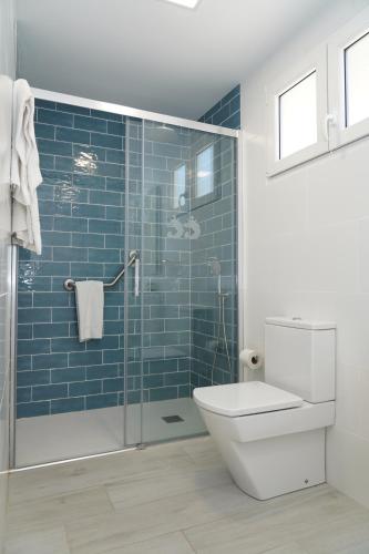 a bathroom with a toilet and a glass shower at Hostal San Juan in El Campello