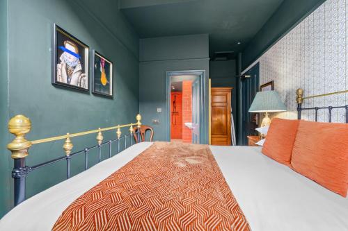 a bedroom with a bed and a blue wall at Clementine's Guest House in York