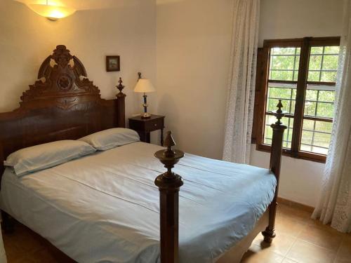a bedroom with a large bed with a wooden headboard at Sa Sort de Can Moix in Alaró