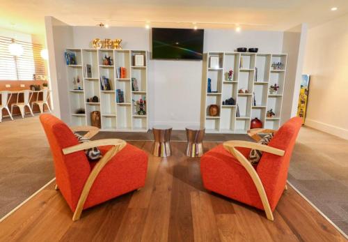 a room with two chairs and a table and shelves at Pool - WiFi - Parking - Best Location ! in Kissimmee