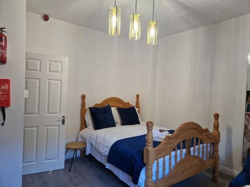 1 dormitorio con cama de madera y almohadas azules en Ideal for short stays en Cork